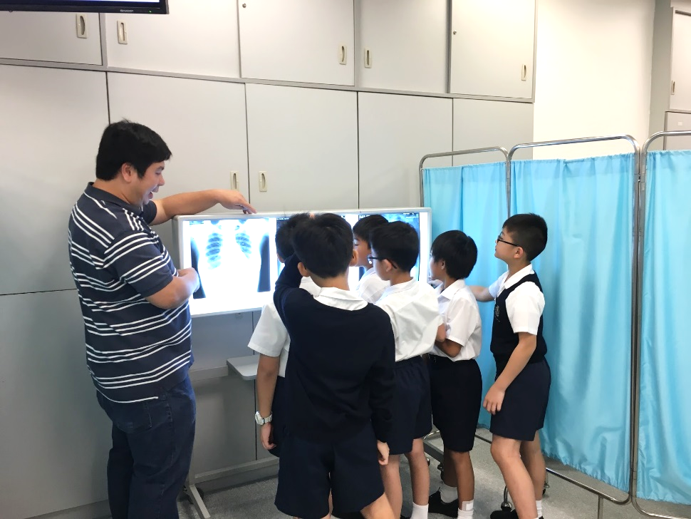 Dr Michael Chan introducing the techniques of chest x-ray observation to students from St. Paul 's College Primary School.
