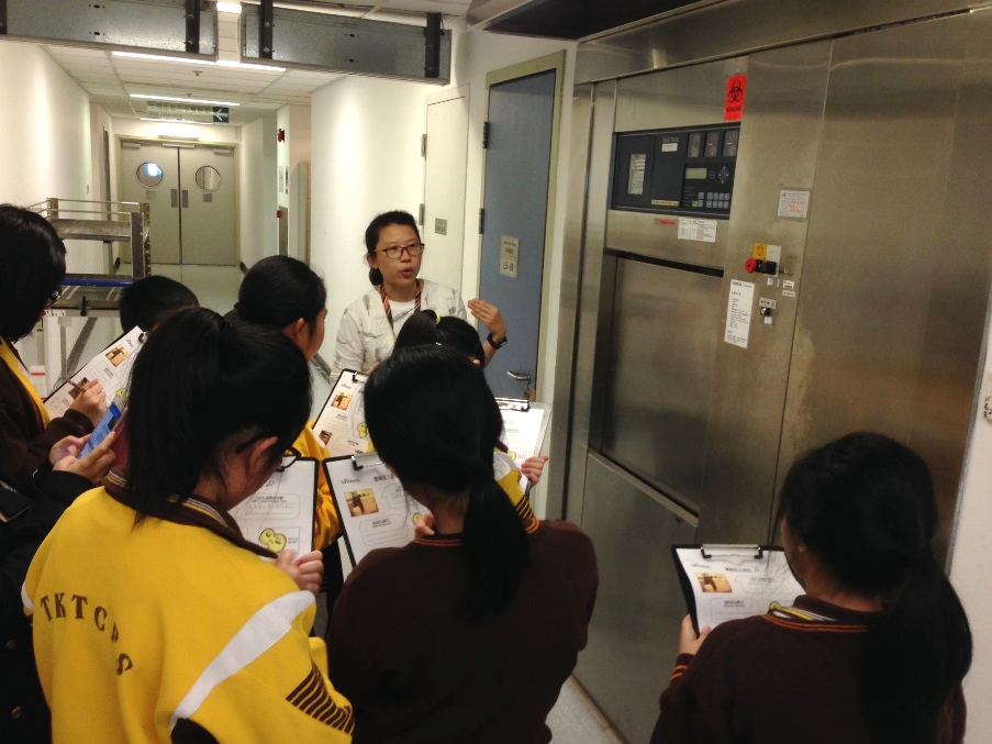 Ms Denise Kuok, Education Ambassador, describing how autoclave works to decontaminate laboratory utensils and wastes to students from Tai Kok Tsui Catholic Primary School on 2 December 2017.