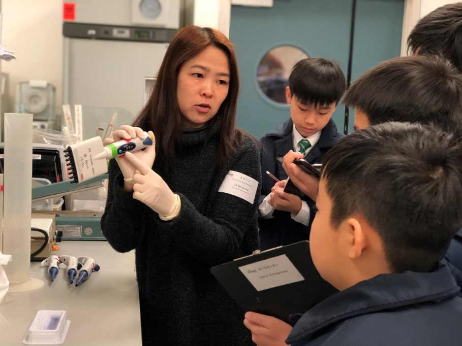 Dr Kenrie Hui, Education Ambassador, showing a multi-channel pipette to students from St. Joseph's Primary School.